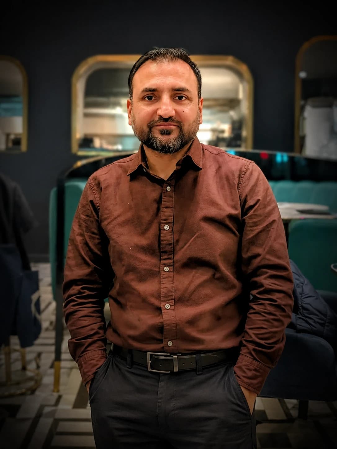 Tanzeel, standing, in a brown shirt